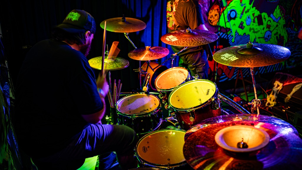 Drummer under neon lights with colorful background