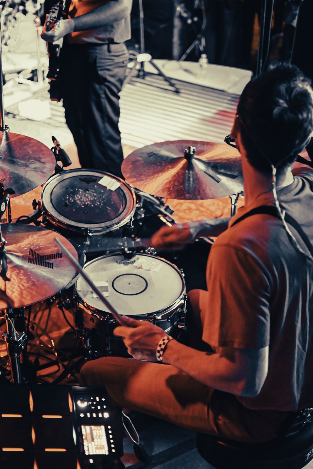 Drummer from above, cymbals in orange and teal