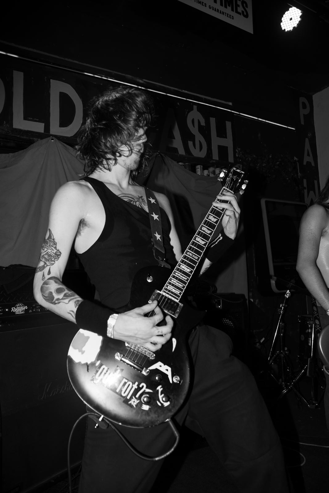 Guitarist in a star-strap tank, black and white flash