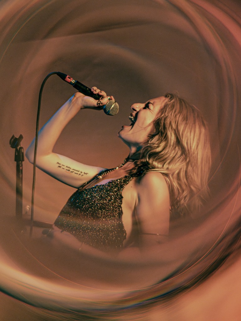 Vocalist mid-performance, swirling lights